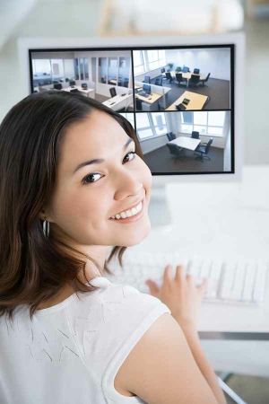 Happy girl_watching a security camera monitor at the office