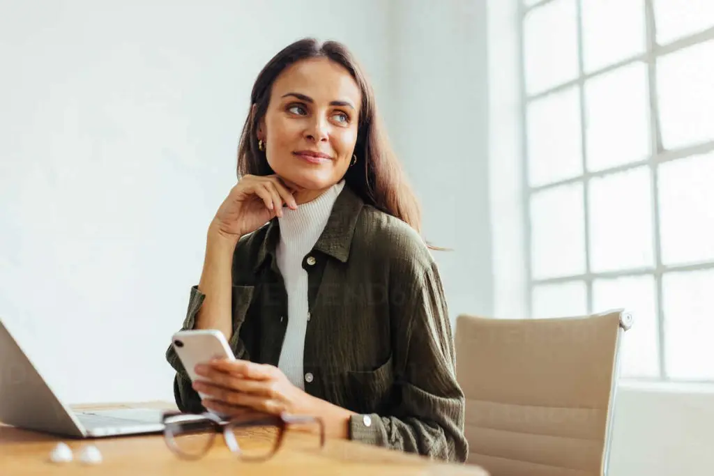 thoughtful-business-woman-smartphone-in-her-hand