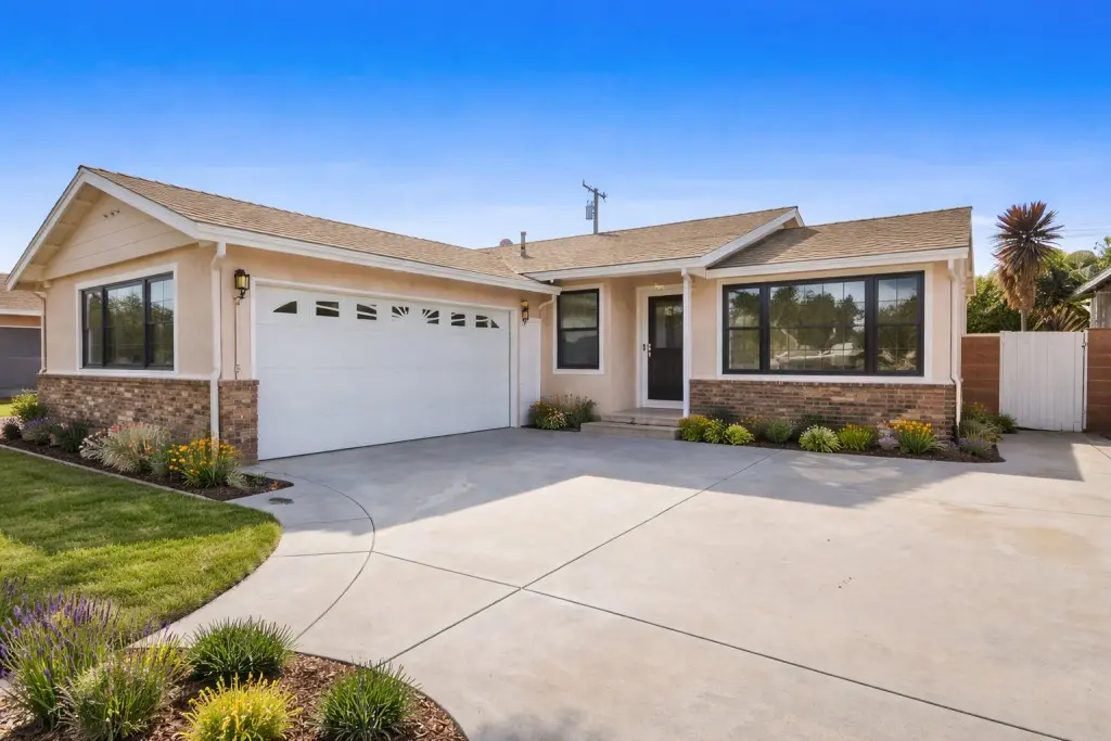 Modern residential home in Artesia, CA with upgraded large windows and driveway exterior view