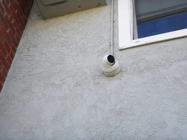 Security camera installation in Cerritos facing back door with painted conduit piping for a clean finish