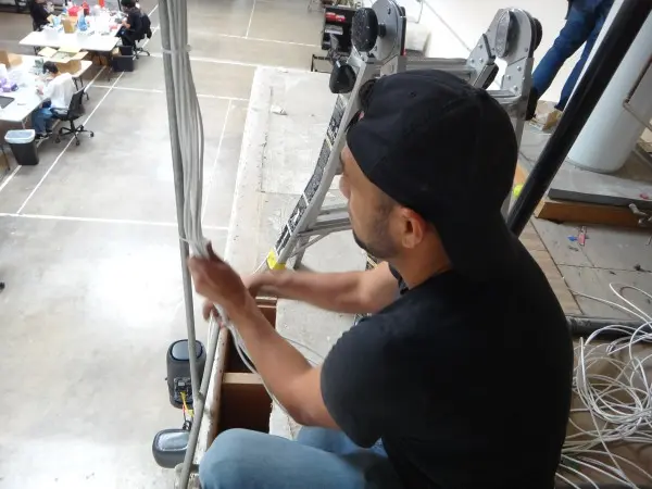 Installer organizing and securing security camera wiring for a clean and reliable installation