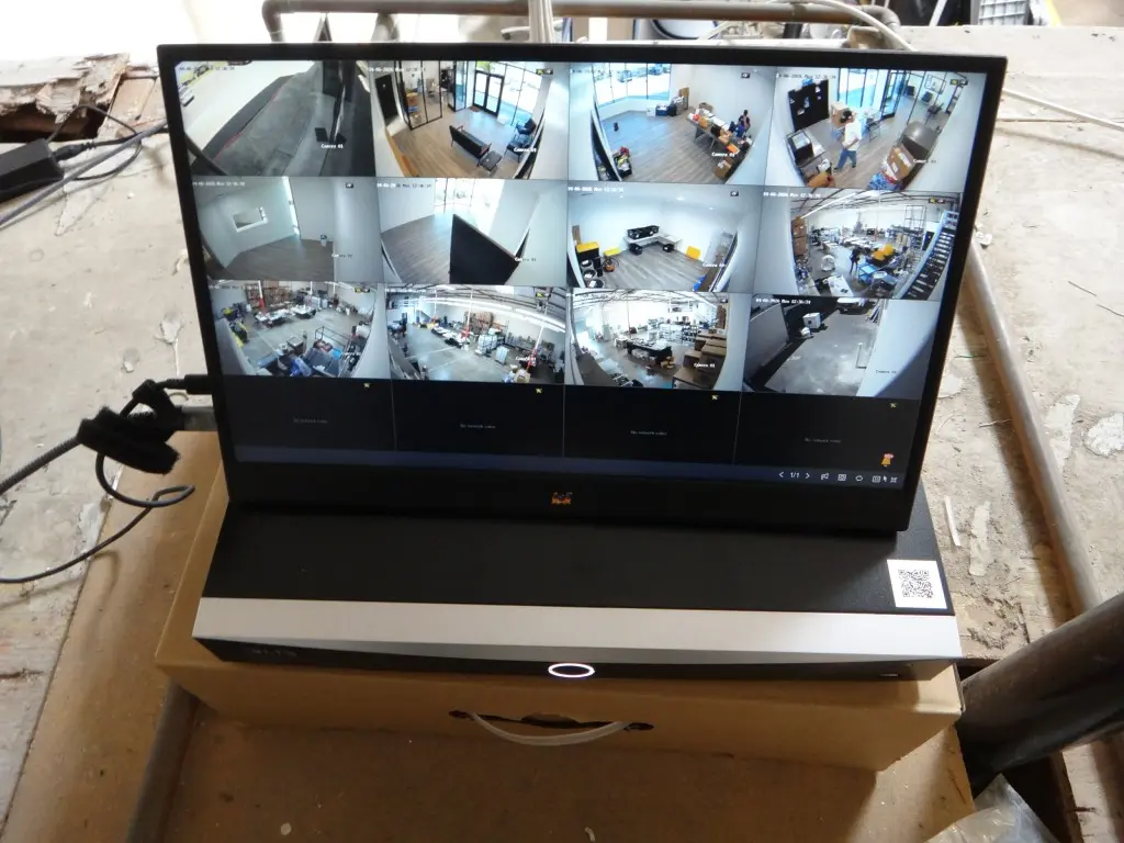 Security camera system connected to NVR and monitor displaying live views from multiple cameras