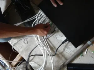 Installer connecting security camera system to NVR for video recording and monitoring setup