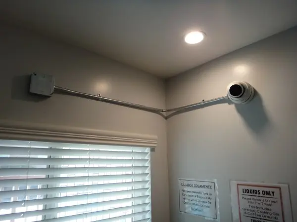 Security camera installation in kitchen area with conduit piping for protected wiring