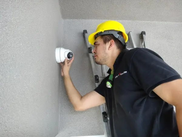 technician installing security camera on ladder in La Mirada CA