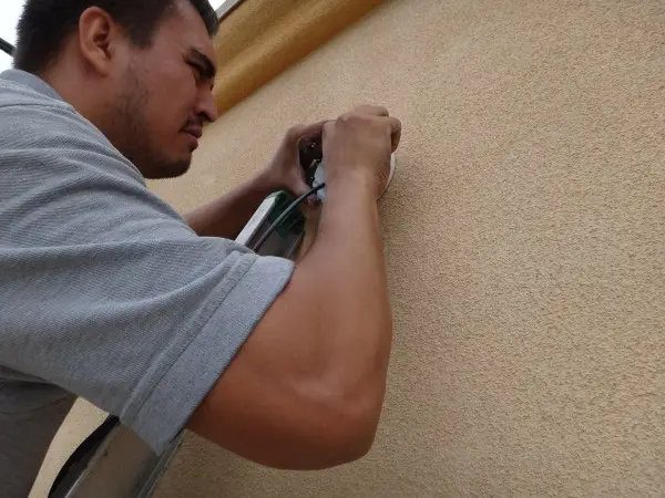 Technician running wiring during commercial security camera installation in Buena Park CA