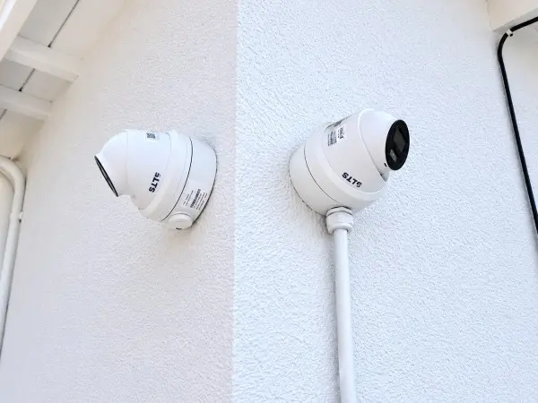 Dual security camera corner installation showing residential surveillance coverage and camera placement