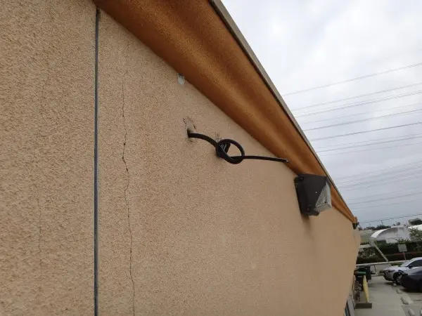Security camera wiring routed along roof border during commercial installation 