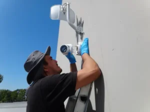 Installer mounting a security camera and securing network connections inside a weatherproof junction box commerce ca