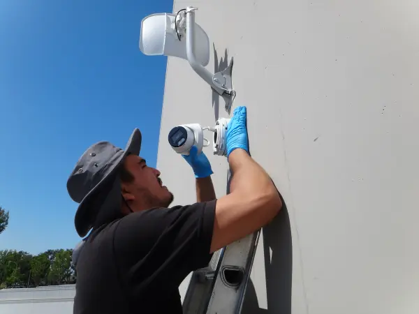 Installer mounting a security camera and securing network connections inside a weatherproof junction box commerce ca