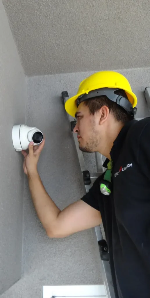 Security camera installer adjusting an outdoor surveillance camera during a residential security camera installation in El Monte CA.