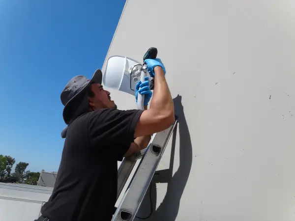 Ubiquiti wireless bridge installation in Commerce CA providing a 500-foot wireless connection between a commercial office and remote security cameras at a truck gate.