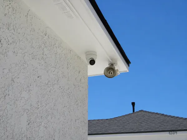 Outdoor security camera mounted on the corner of a residential home providing wide-area surveillance coverage in Lakewood, CA.