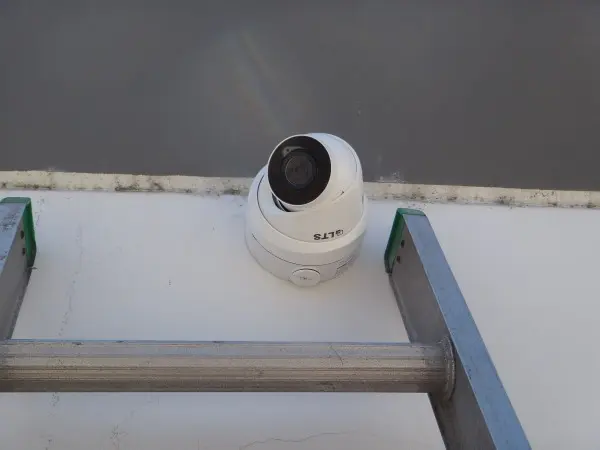 Commercial security camera mounted on warehouse exterior wall