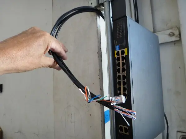 Commercial PoE switch with Cat6 network cabling for a warehouse security camera installation