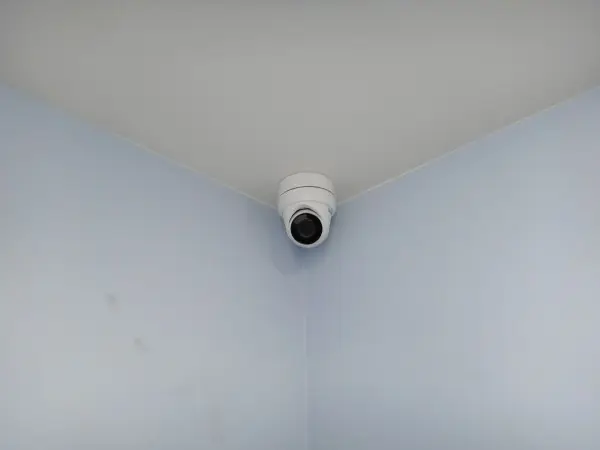 Indoor security camera installed in the corner of a residential room for complete interior surveillance coverage.