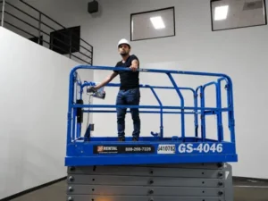 Protection4Less technician using a scissor lift to install security camera wiring in a commercial warehouse