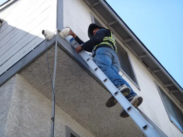 Protection4Less technician installing a 4K security camera on a home in Azusa, CA