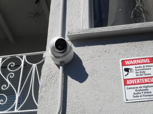 Security camera installed with exterior conduit on apartment building
