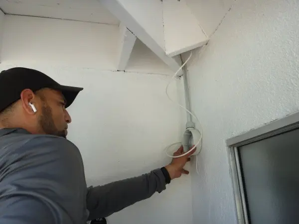 Technician installing a security camera at a home in Fullerton CA